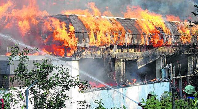 Flammen schlagen auf breiter Front aus dem Konstanzer Schwaketenbad. Nicht nur die Dachkonstruktion brennt, auch in die Schwimmhalle ...