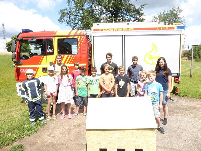 Zu Beginn des Komminger Ferienprogramms „Wasser marsch“ versammeln sich die Teilnemer vor dem Feuerwehrauto.