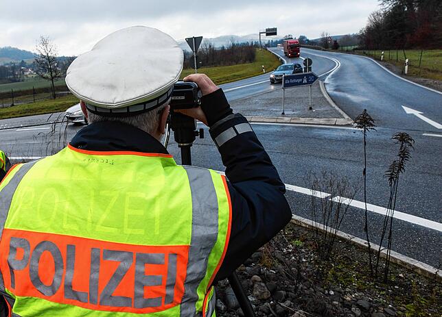 Ein Polizist kontrolliert bei Gottmadingen am Ende der A81 mit einem Lasermessgerät die Geschwindigkeit der Fahrzeuge.