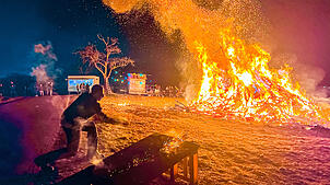 Eine glühende Holzscheibe wird in den Funken geschlagen. Es handelt sich um einen Rügebrauch. Die Feuerscheiben werden Bürgern und ihren ...