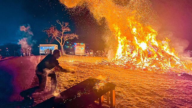 Eine glühende Holzscheibe wird in den Funken geschlagen. Es handelt sich um einen Rügebrauch. Die Feuerscheiben werden Bürgern und ihren ...