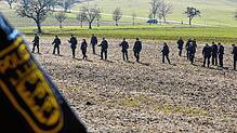 Einsatzkräfte der Polizei suchen ein Gebiet ab. Eine Spaziergängerin hat im Februar auf einer Wiese in Steinen (Landkreis Lörrach) einen ...