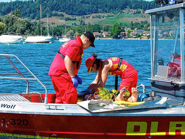 Kurz nachdem der verletzte Wassersportler an Bard des Rettungsboots ist, wird er gesichert und mit einer Decke vor Wärmeverlust ...