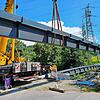 Ein tonnenschwerer Stahlträger der neuen Brücke über die Schlücht schwebt in Gurtweil an Ort und Stelle.