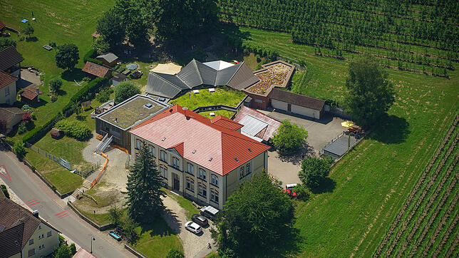 Die Tanne vor der Schule kommt bald weg. Die Mauer hinter dem Brunnen ebenfalls. Sowohl bei Schule als auch Kindergarten geht es bald ...