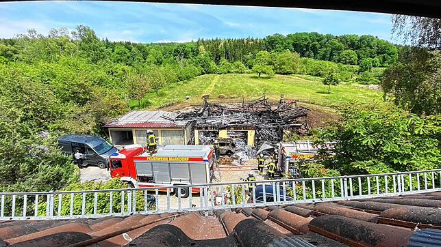 Am Tag nach dem Brand im Lilienweg: Die Feuerwehr ist noch vor Ort vor der abgebrannten Scheune. Selbst die darunter liegenden Garagen ...