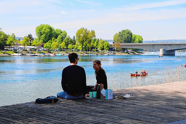 Dieses Duo genießt das schöne Wetter am Ufer des Seerheins. Auch auf dem Wasser sind die ersten unterwegs &ndash; hier paddeln zwei ...