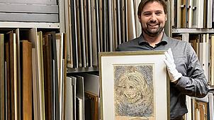 Museumsleiter Julian Windmöller zeigt eine der Grafiken, die für die Dalí-Sonderausstellung in einem der Depoträume des Museums bereit ...