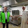 Karl und Sebastian Amann zeigen frische Bauernbratwürste, die für das Schlachtfest zubereitet wurden.