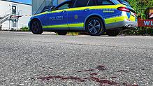 Am Tag nach der Messerattacke eines Bewohners der Asylbewerberunterkunft in Kressbronn sind noch Blutspuren auf der Straße vor dem ...