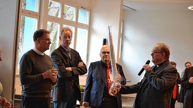 Ein besonderes Geschenk hat Pfarrer Jan Grzeszewski (rechts) für Dekan Peter Nicola (links) bereit: Ein Regenschirm mit einer Zeichnung ...