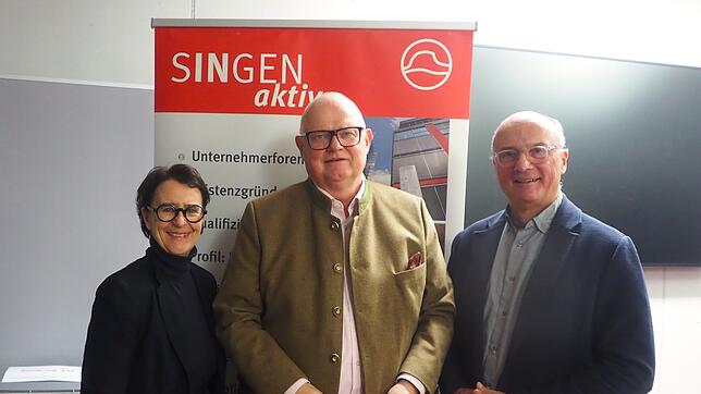 Geschäftsführerin Claudia Kessler-Franzen und der Vorsitzende des Vereins Singen aktiv, Wilfried Trah, rahmen den Referenten Martin W. ...