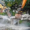 Staub wirbelt auf, als die Greifer der Spezialbagger die letzten Verbindung der Schlüchtbrücke kappen.