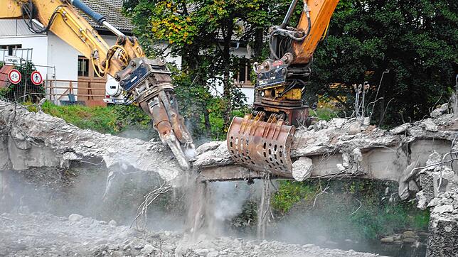 Staub wirbelt auf, als die Greifer der Spezialbagger die letzten Verbindung der Schlüchtbrücke kappen.