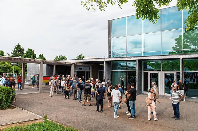 Zahlreiche Menschen stehen vor Beginn der AfD-Veranstaltung an der Stadthalle am Einlass.