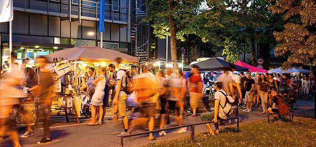 Typische Abend- und Nachtatmosphäre im Jahr 2019: Einige machen es sich am Rand gemütlich und lassen den Besucherstrom an sich ...
