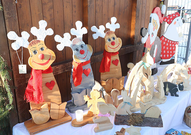 Beim Weihnachtsmarkt am Kreistierheim stehen vierbeinige Holzskulpturen im Vordergrund.