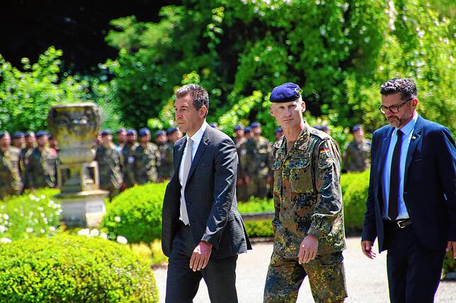 Oberbürgermeister Erik Pauly (links) läuft mit Brigadegeneral Christian Friedl und dem FDP-Landtagsabgeordneten Niko Reith die Truppe ab.