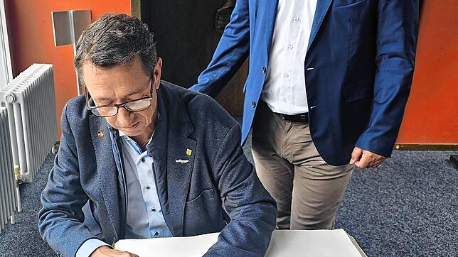 Gemeindepräsident Thomas Müller trägt sich ins Goldene Buch ein, rechts Bürgermeister Ralf Baumert. Bild: Gemeinde