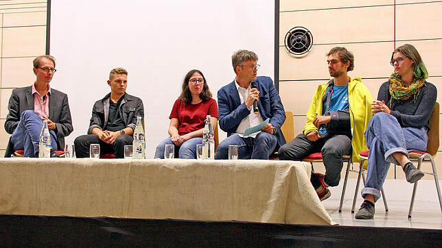 Junge Vertreter der Fridays-for-Future-Bewegung in einer Podiumsdiskussion mit dem Referenten, Autor und Journalisten Fabian Scheidler ...
