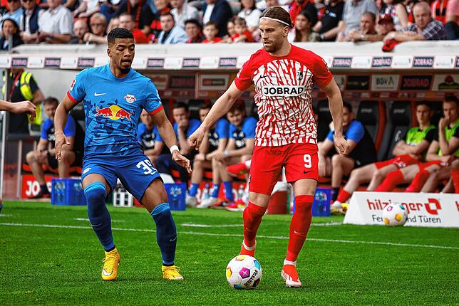 Leipzigs Benjamin Henrichs (l) und Freiburgs Lucas Höler (r) im Zweikampf.
