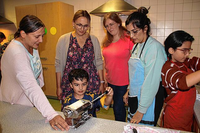 Mit Eifer drehte Hadis (vorne) die Kurbel der Nudelmaschine. Gemeinsam mit seiner Mutter Wida, 2.v.r Schwester Zuha (rechts), ...