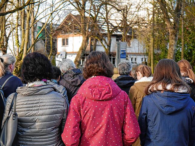 Die Kirchengemeinde der Friedenskirche kam am Montag zu einem Gottesdienst zusammen. Im Hintergrund das zerstörte Gemeindezentrum.
