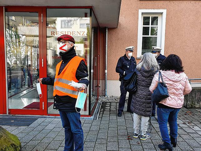 Während Polizisten Personalien von Maskenverweigerern aufnehmen (rechts), verteilt ein Ordner Masken für Teilnehmer, die ohne ...