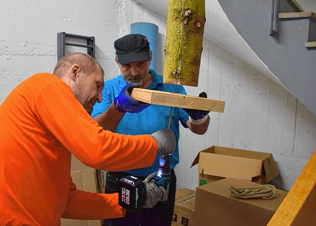 Geselle Michael Bohl (links) und Zimmerermorschter Frank Eckardt setzen den Baum im Keller.