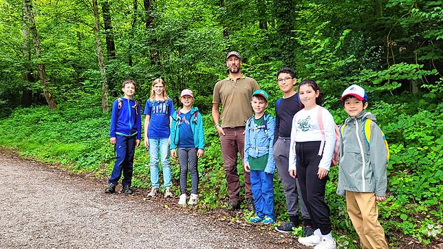 Stadtförster Gabriel Hieke (Mitte) informiert die Kinder beim Walderlebnistag im Sommerferienprogramm über diesen Lebensraum. Foto: ...