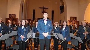 Beim Kirchenkonzert in Albbruck: Dirigent Andrea Bossi inmitten von Mitgliedern des Blasorchesters Albbruck und Gastmusikern aus anderen ...