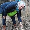 Petra Hans, Helferin des Umweltzentrums, setzt die Erdkröte in der Nähe eines kleinen Weihers auf den Boden.