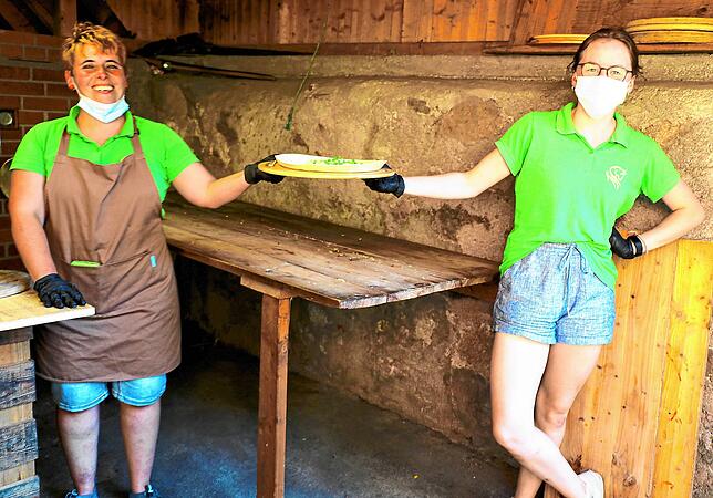 Barbara Bruker-Wernet (links) hat die Pizza für die Feriengäste fertig. Elisabeth Feist seviert.