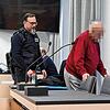 Der 84-jährige Angeklagte wird von einem Justizvollzugsbeamten zu seinem Platz begleitet.