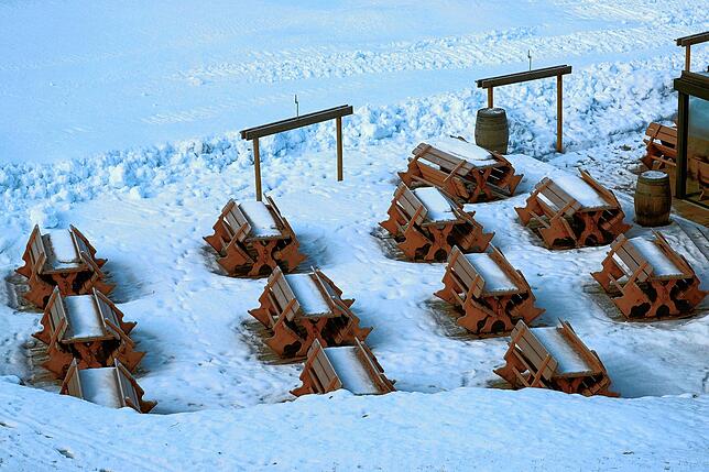 Schnee bedeckt Bänke und Tische an einer gesperrten Skipiste in Fieberbrunn. Solche Bilder wie das von 2020 wollen die ...