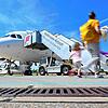 Passagiere laufen auf dem Bodensee-Airport mit Gepäck zum Flieger.