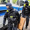 Berlin: Polizisten tragen bei einer Hausdurchsuchung in Berlin-Kreuzberg einen Karton zu einem Fahrzeug.