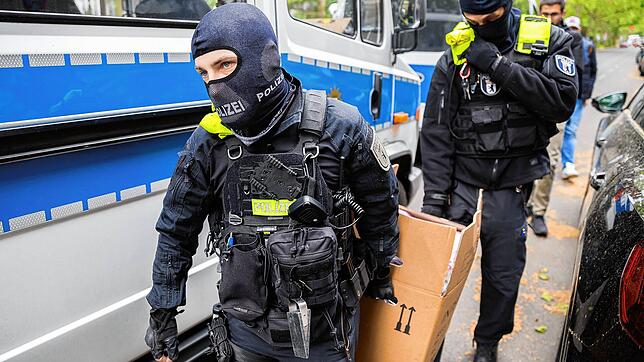 Berlin: Polizisten tragen bei einer Hausdurchsuchung in Berlin-Kreuzberg einen Karton zu einem Fahrzeug.
