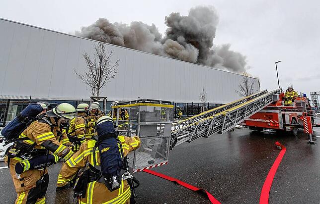 Dicke Rauchwolken steigen auf. Rund 300 Einsatzkräfte und mehr als 100 Fahrzeuge der Feuerwehren sind bis in die Nacht hinein am Brandort.