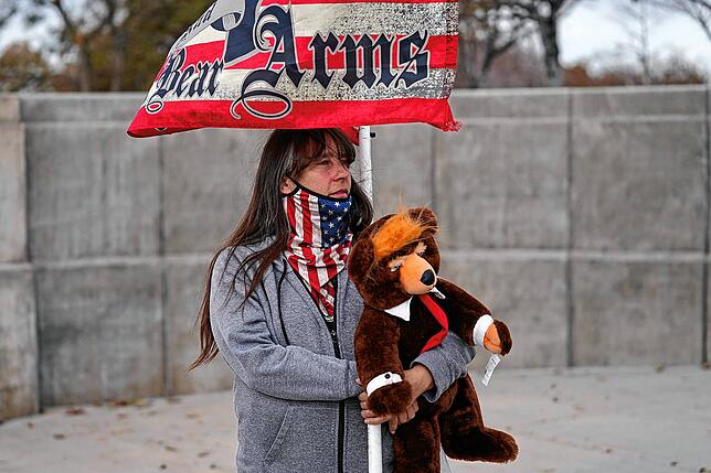 Eine Anhängerin von US-Präsident Trump hält während einer Kundgebung einen Teddybären und eine Flagge mit der Aufschrift “Bear ...