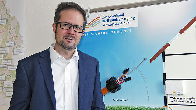 Zweckverband Geschäftsführer Jochen Cabanis steht vor einer Infotafel zum Breitbandausbau mit Glasfaser. Bild: Jens Fröhlich