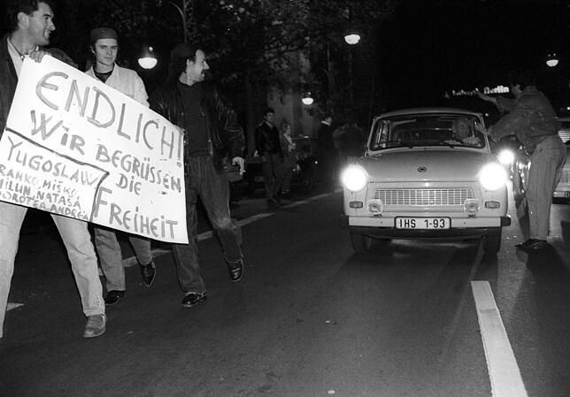 Öffnung der Grenze am 9. November 1989: Trabis werden von einer begeisterten Menge an einem Grenzübergang in Berlin begrüßt.