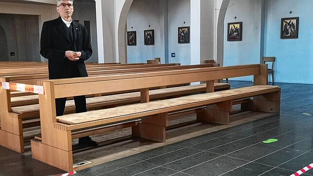 Pfarrer Karlheinz Brandl in der St.-Andreas-Kirche: Auf den Boden geklebte Silhouetten von Fußabdrücken geben die Laufrichtung im ...