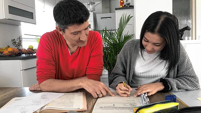 Christian Bausch hilft seiner Tochter Ronja bei den Mathe-Aufgaben.
