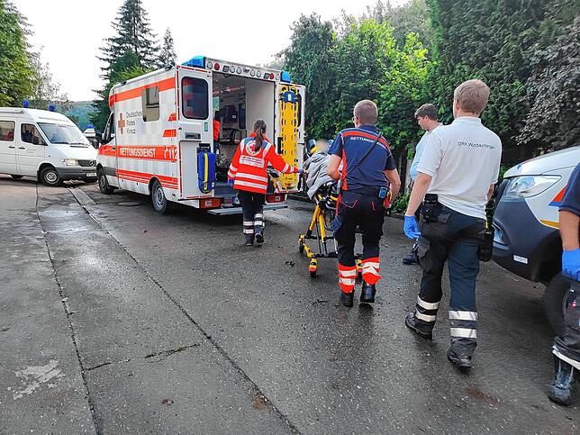 Einer der bettlägerigen Bewohner wird ins Auto geschoben.