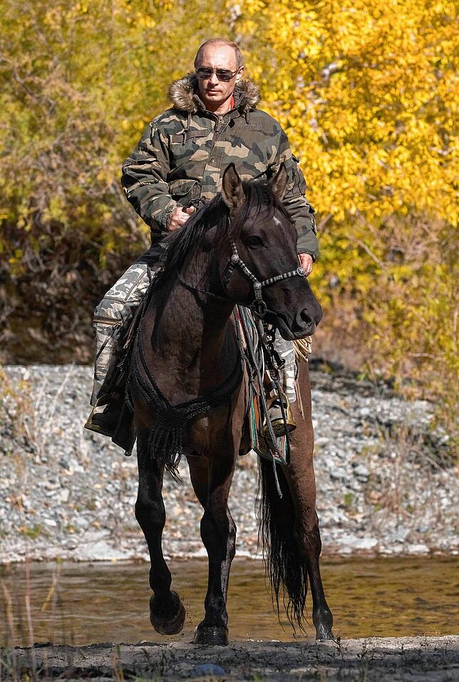Inszeniert sich auch privat gern als starker Mann: Putin in Militärjacke und Sonnenbrille hoch zu Ross.