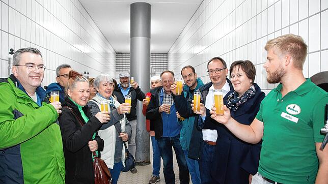 Prost: Im Lagerkeller stößt Braumeister Steffen Müller (rechts) mit den Teilnehmern der SÜDKURIER-Leserführung mit frisch gezapftem Bier an.
