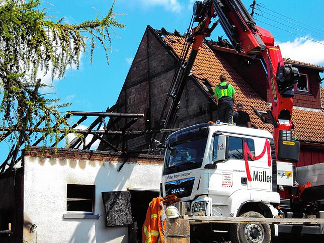 Mit einem Kran der ortsansässigen Firma Holzbau Müller wird das sich auf dem Heustock befindende Heu herausbefördert und abgelöscht.