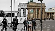 Im Wandel der Zeit: Einst patrouillierten Grenzpolizisten vor der Mauer am Brandenburger Tor, heute kommen Besucher aus der ganzen Welt ...