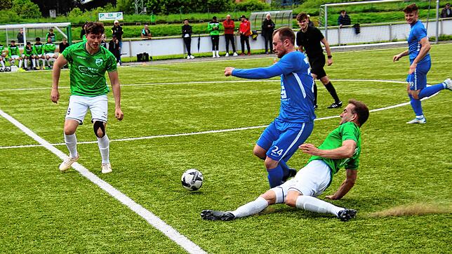 DJK-Spielertrainer Jonas Schwer grätscht dem Hegauer Anton Müller den Ball weg. Tim Stolz (links) verfolgt die Szene.